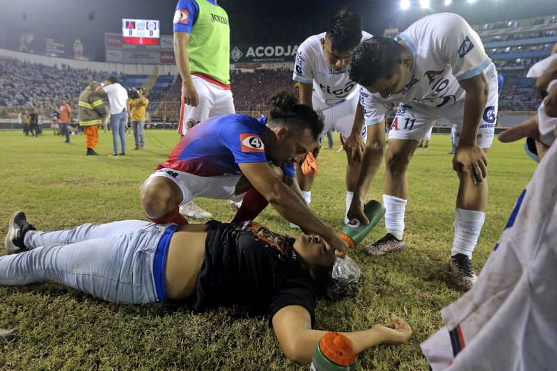 Jugadores de FAS y Alianza atienden a una hincha. / Milton Flores / AFP